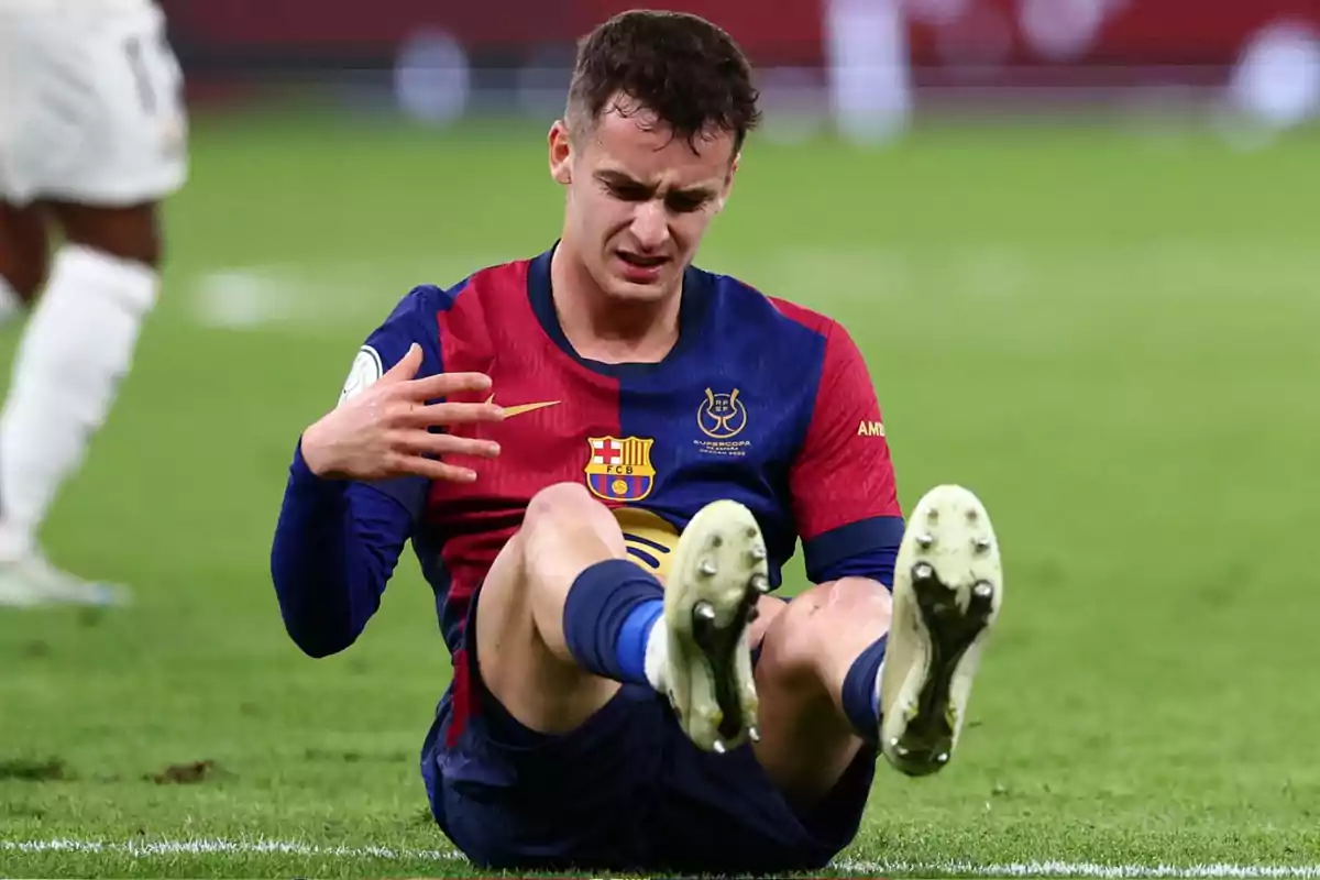 Barcelona player sitting on the grass with a pained expression after a possible injury during a match Barcelona player sitting on the grass with a pained expression after a possible injury during a match