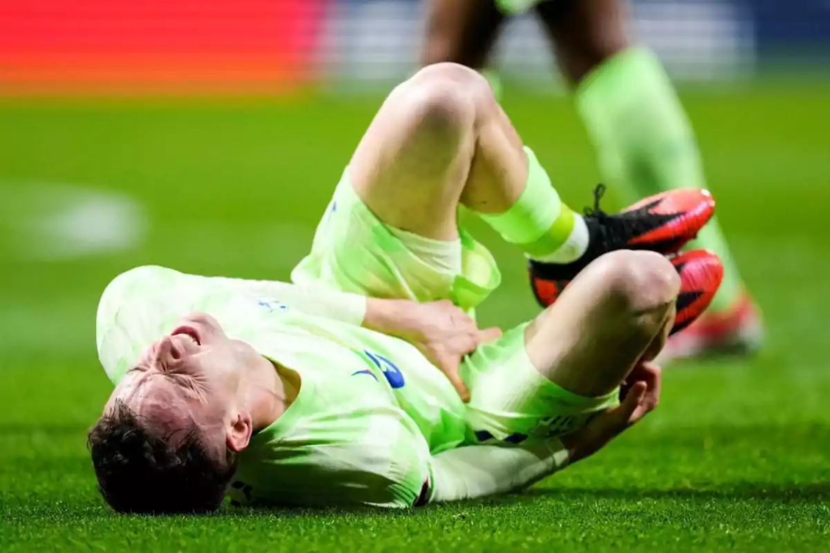 Soccer player lying on the grass with a pained expression, holding his leg during a match Soccer player lying on the grass with a pained expression, holding his leg during a match
