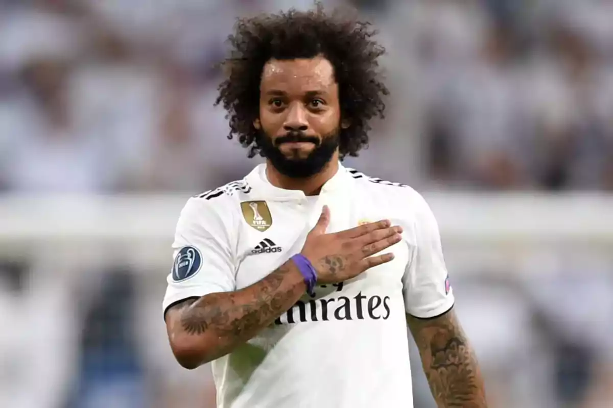 A soccer player in a white uniform puts his hand to his chest in a stadium. A soccer player in a white uniform puts his hand to his chest in a stadium.