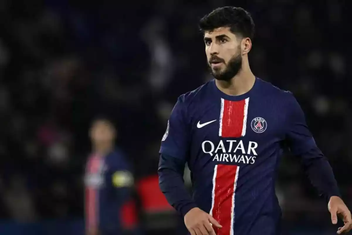 Un jugador de fútbol con uniforme azul y rojo del PSG en el campo de juego.