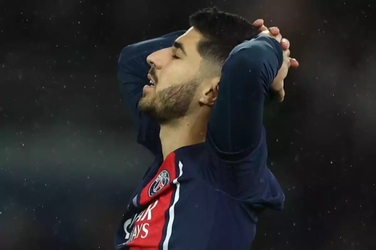 A soccer player wearing a PSG jersey puts his hands to his head in a gesture of frustration. A soccer player wearing a PSG jersey puts his hands to his head in a gesture of frustration.