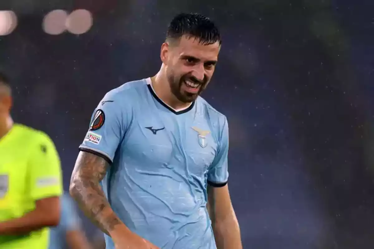 Soccer player in a light blue Lazio jersey smiles in the rain during a match Soccer player in a light blue Lazio jersey smiles in the rain during a match