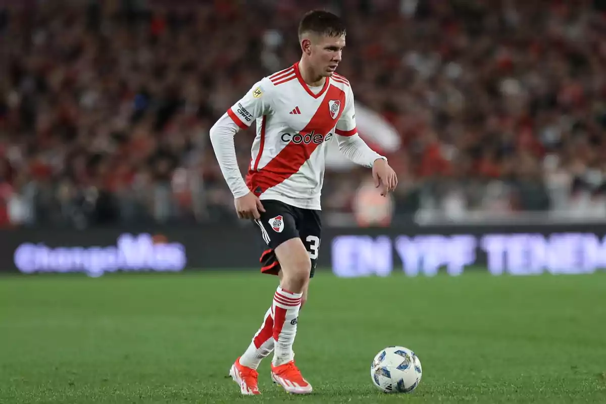River Plate player controlling the ball during a soccer match in a stadium full of spectators River Plate player controlling the ball during a soccer match in a stadium full of spectators