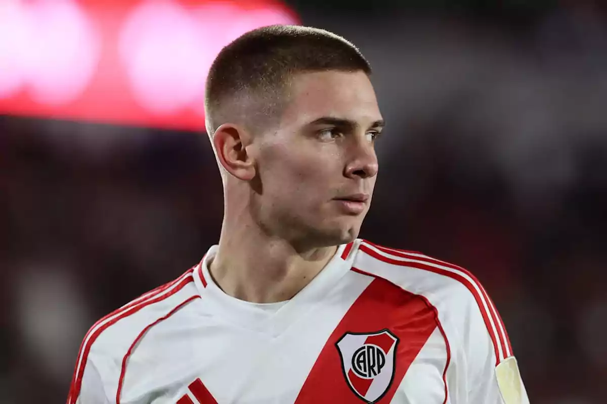 Soccer player wearing a River Plate jersey looking to the side during a match Soccer player wearing a River Plate jersey looking to the side during a match