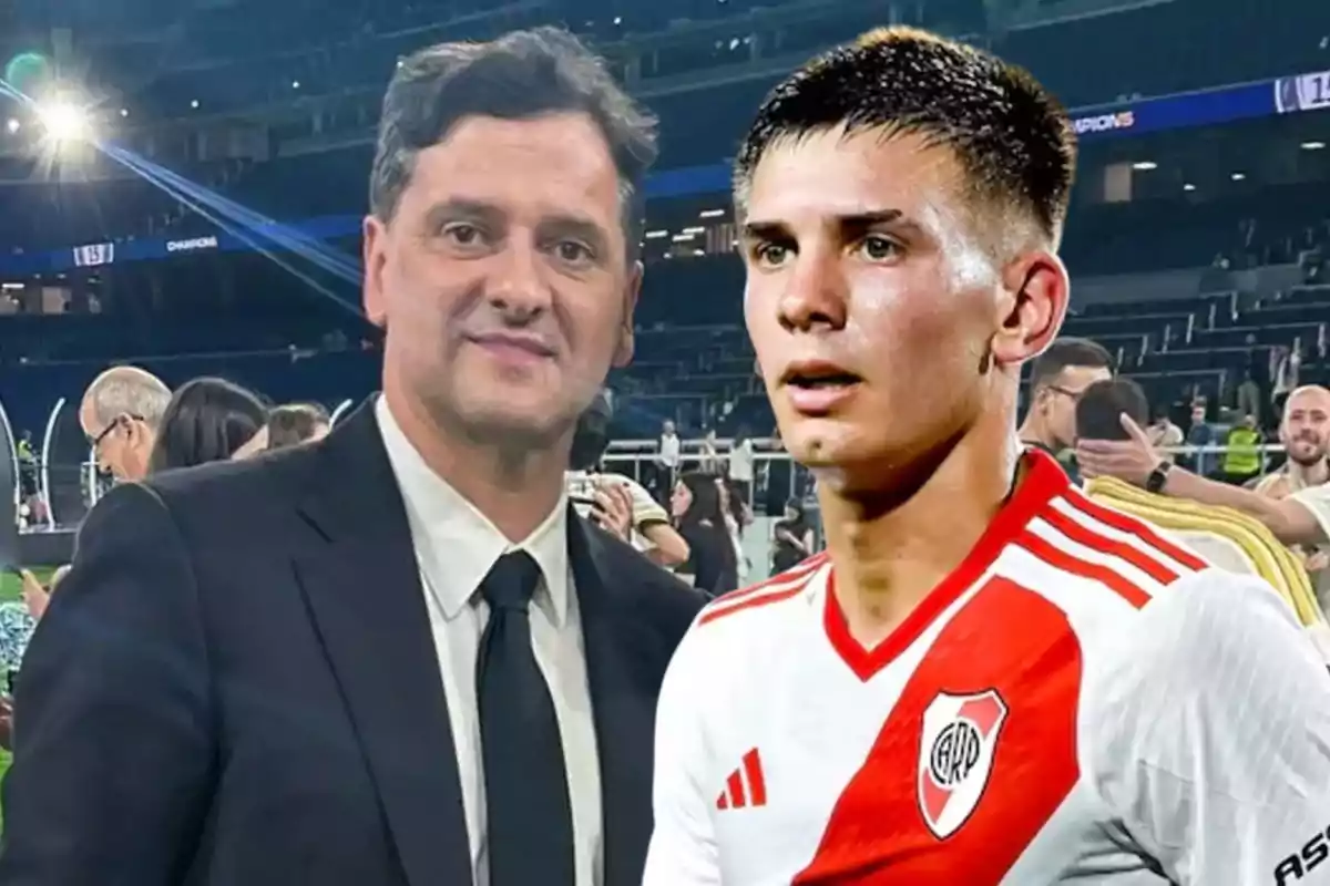 A man in a dark suit and tie poses next to a player in a white and red uniform in a lit-up stadium.