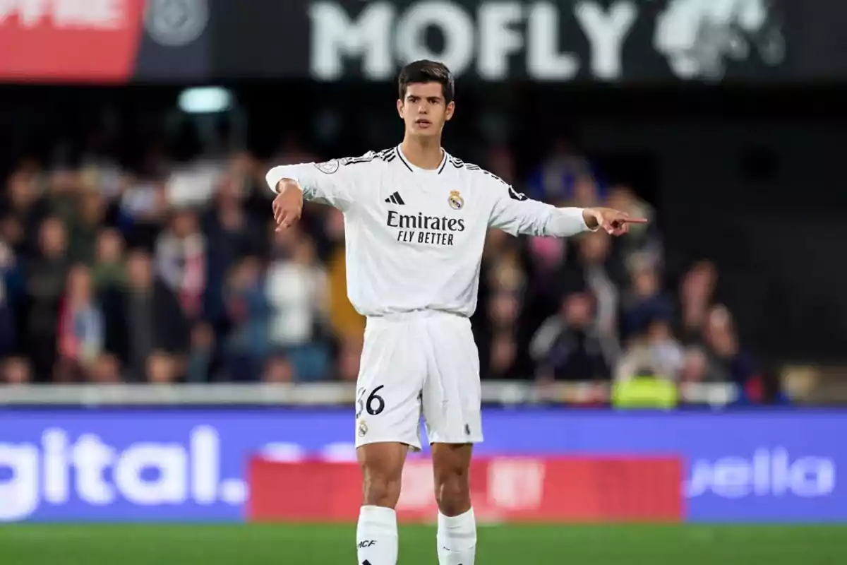 A player in the white Real Madrid uniform is on the field pointing with an outstretched arm during a match. A player in the white Real Madrid uniform is on the field pointing with an outstretched arm during a match.