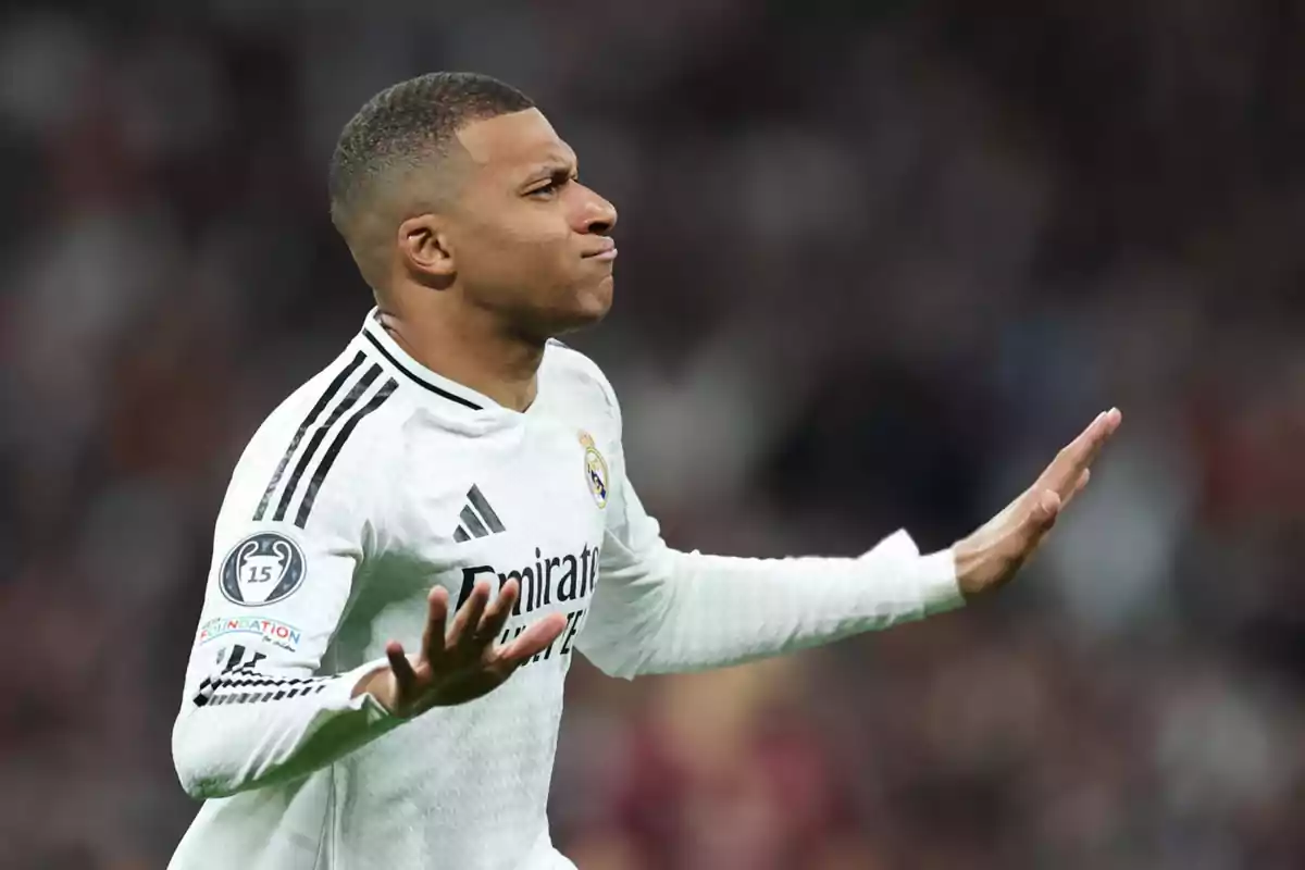 Soccer player in a white uniform on the field making a gesture with his hands.