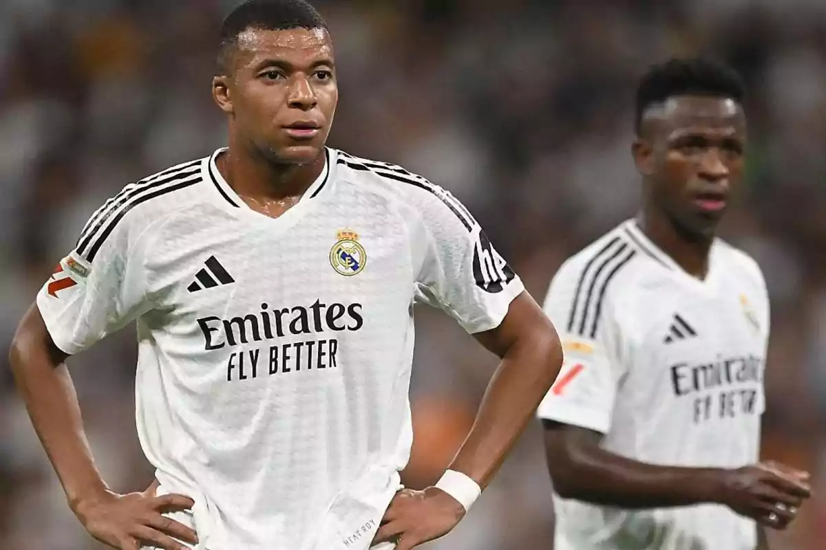 Two players on the field wearing the white uniform of Real Madrid during a match. Two players on the field wearing the white uniform of Real Madrid during a match.