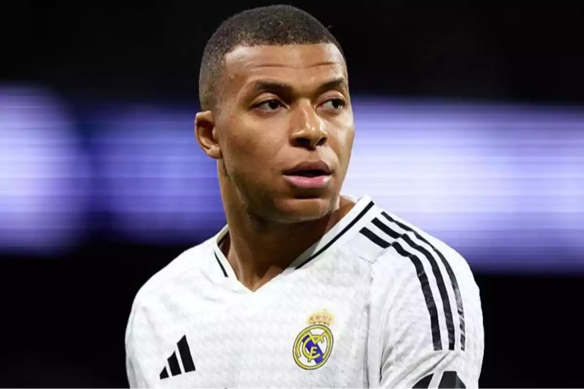 Futbolista con uniforme blanco del Real Madrid mirando hacia un lado en un estadio Futbolista con uniforme blanco del Real Madrid mirando hacia un lado en un estadio
