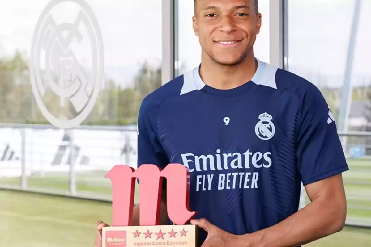 Soccer player in a Real Madrid uniform holding a five-star player trophy on a training field Soccer player in a Real Madrid uniform holding a five-star player trophy on a training field