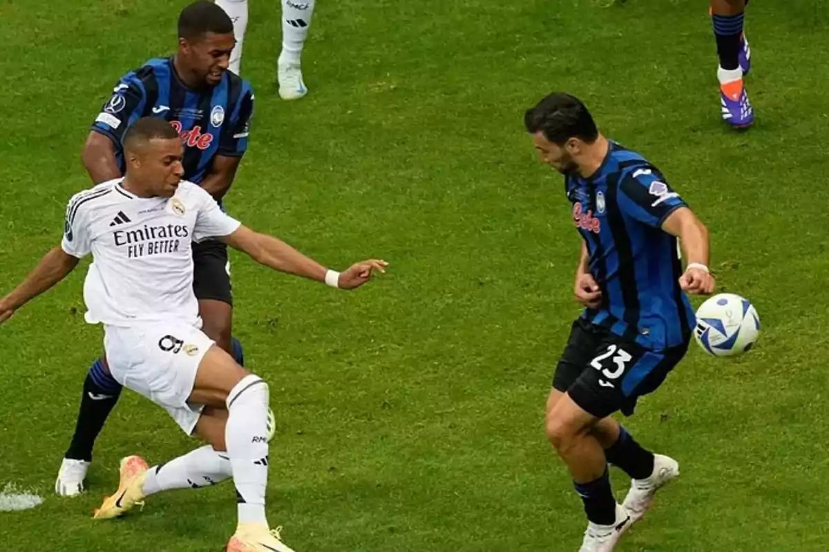 Soccer players in action during a match, one of them tries to control the ball while another approaches to contest the play. Soccer players in action during a match, one of them tries to control the ball while another approaches to contest the play.