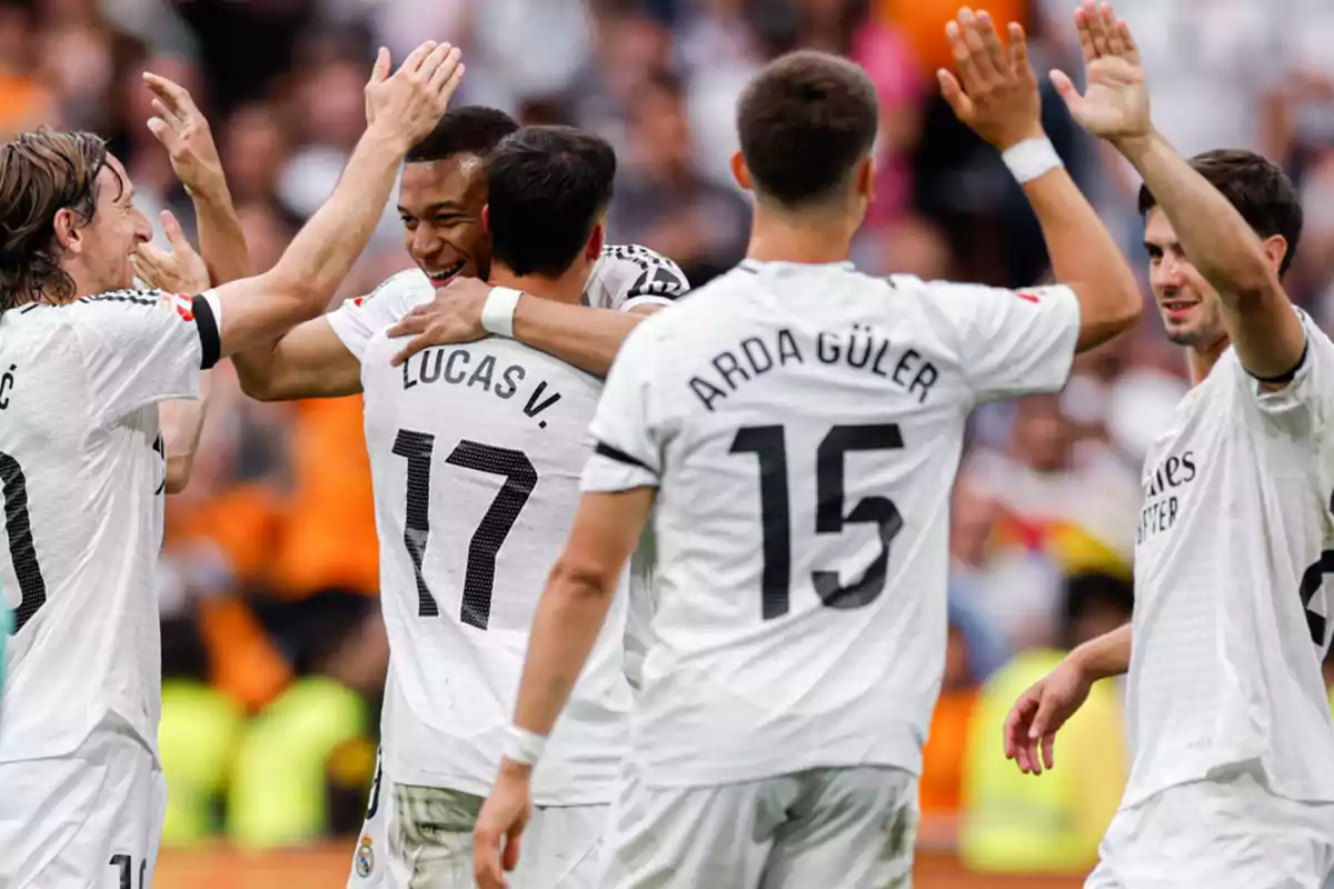 Soccer players celebrating on the field with white jerseys and visible numbers on their backs. Soccer players celebrating on the field with white jerseys and visible numbers on their backs.