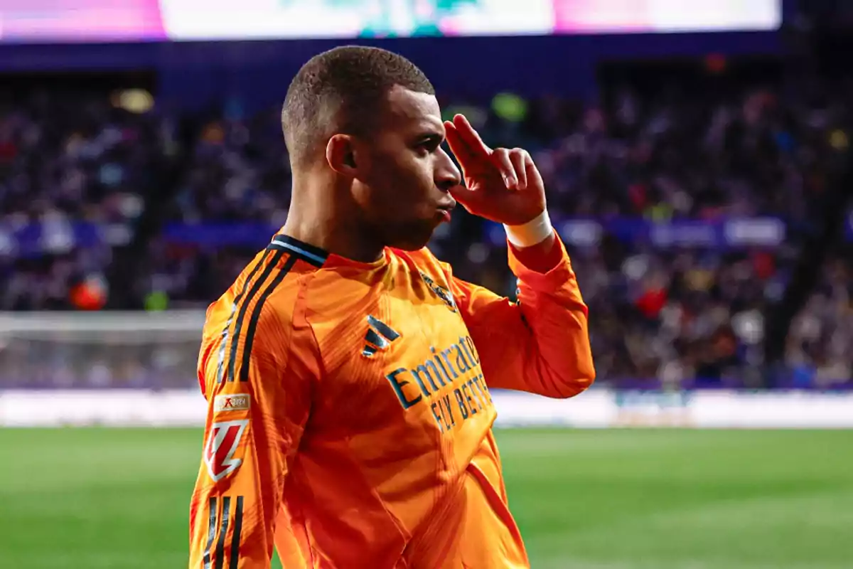 A player in an orange uniform gestures with his hand to his forehead during a game. A player in an orange uniform gestures with his hand to his forehead during a game.