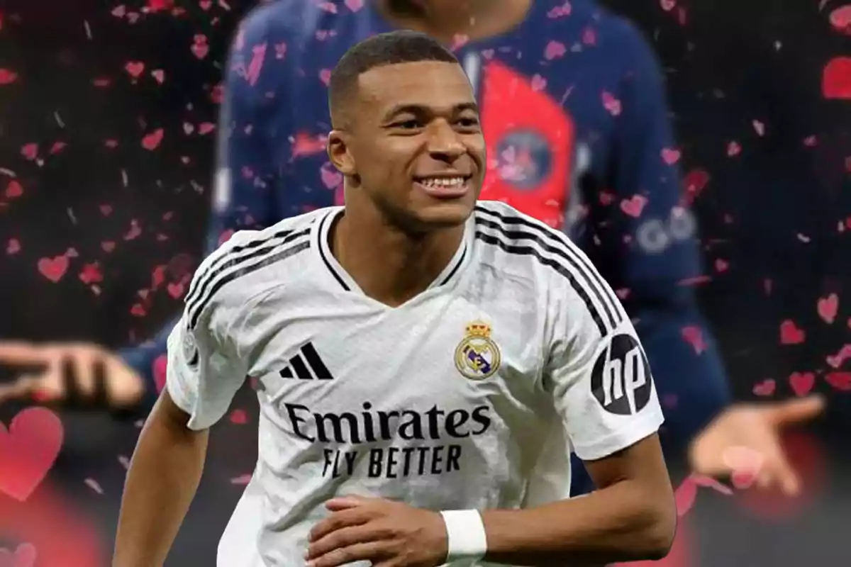 Un jugador de fútbol con la camiseta del Real Madrid sonríe mientras está en el campo con un fondo decorado con corazones.