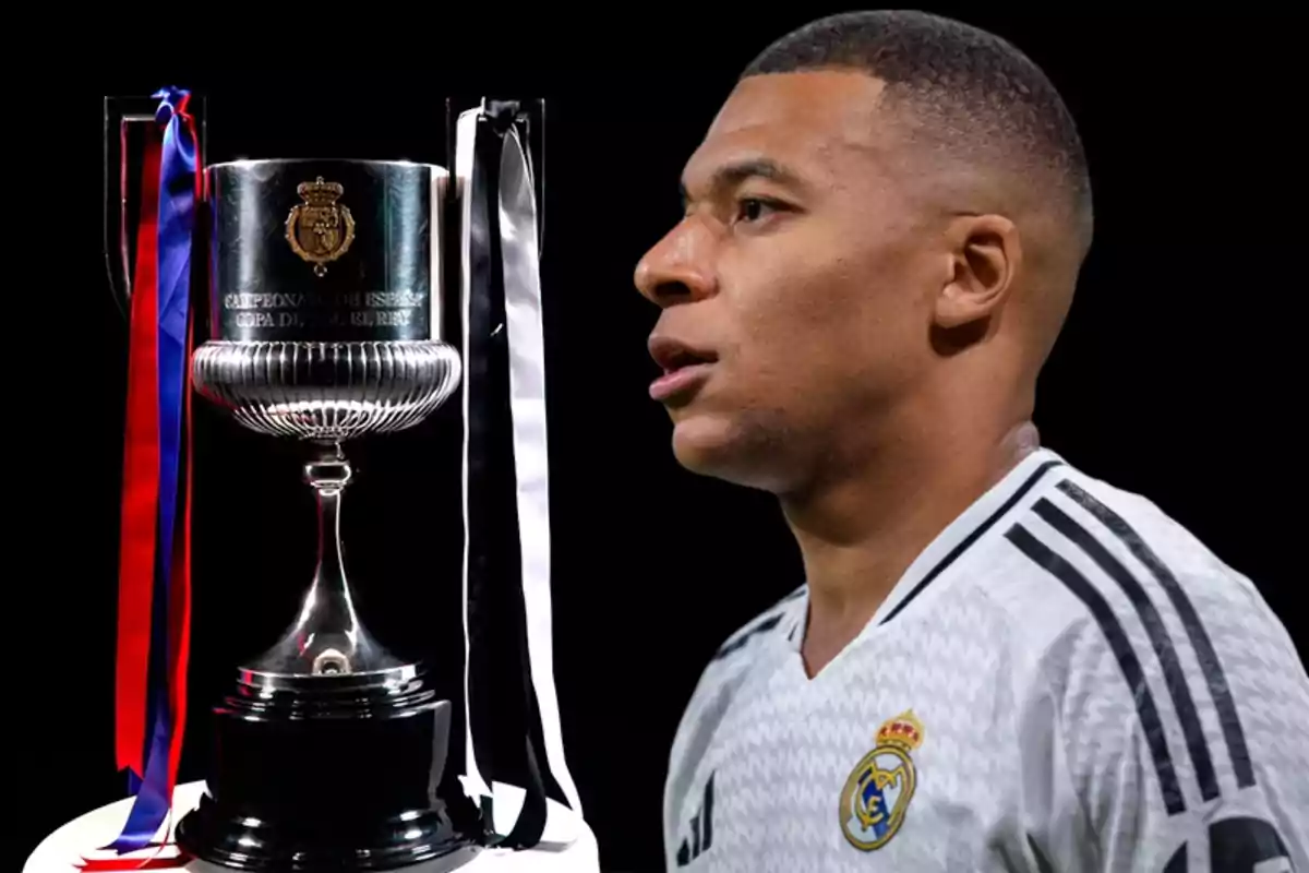 A player in a white jersey next to a Copa del Rey trophy with colorful ribbons.