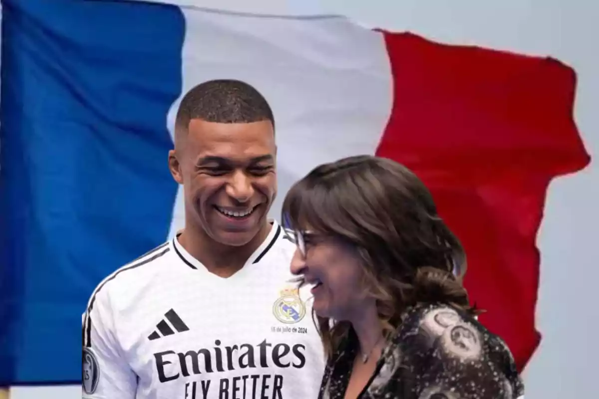 Dos personas sonrientes frente a una bandera de Francia.