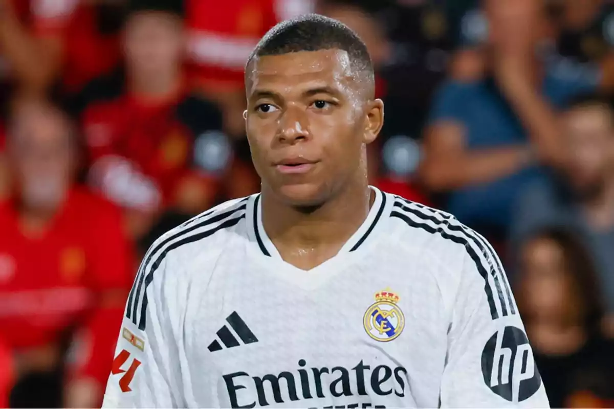 A soccer player in a white jersey in a stadium.