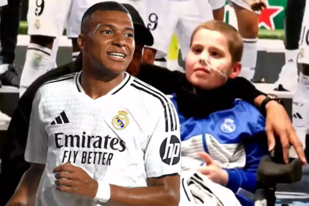 A soccer player in a white uniform stands next to a boy in a wheelchair wearing a blue jacket.