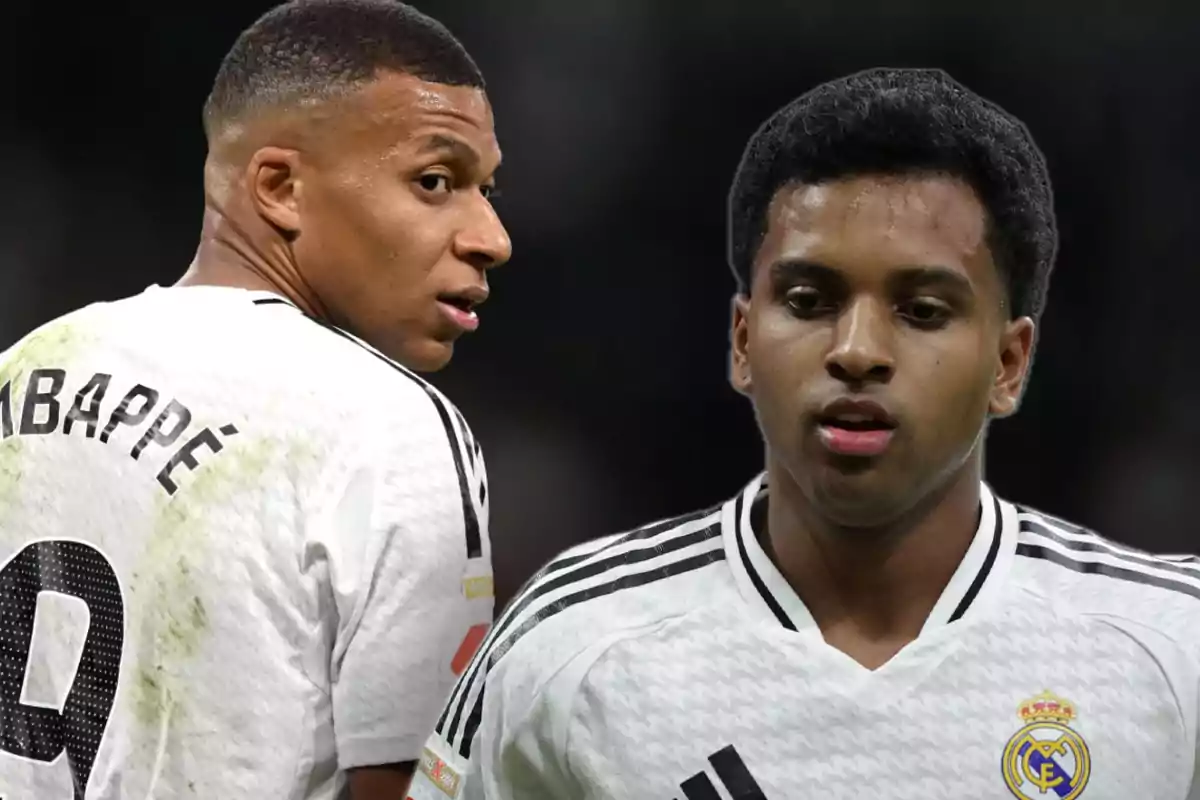 Dos jugadores de fútbol con camisetas blancas en el campo.