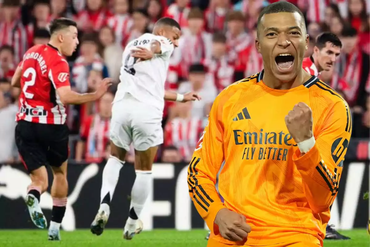 Un jugador de fútbol con uniforme naranja celebra con el puño cerrado mientras en el fondo se desarrolla un partido entre equipos con uniformes rojo y blanco y blanco.