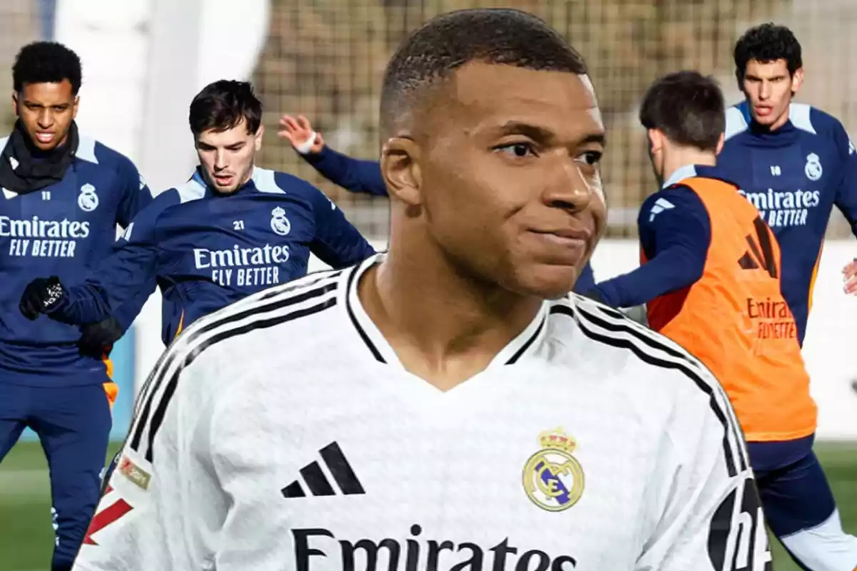 A soccer player in a white Real Madrid uniform in the foreground and several players training in the background in blue training uniforms.