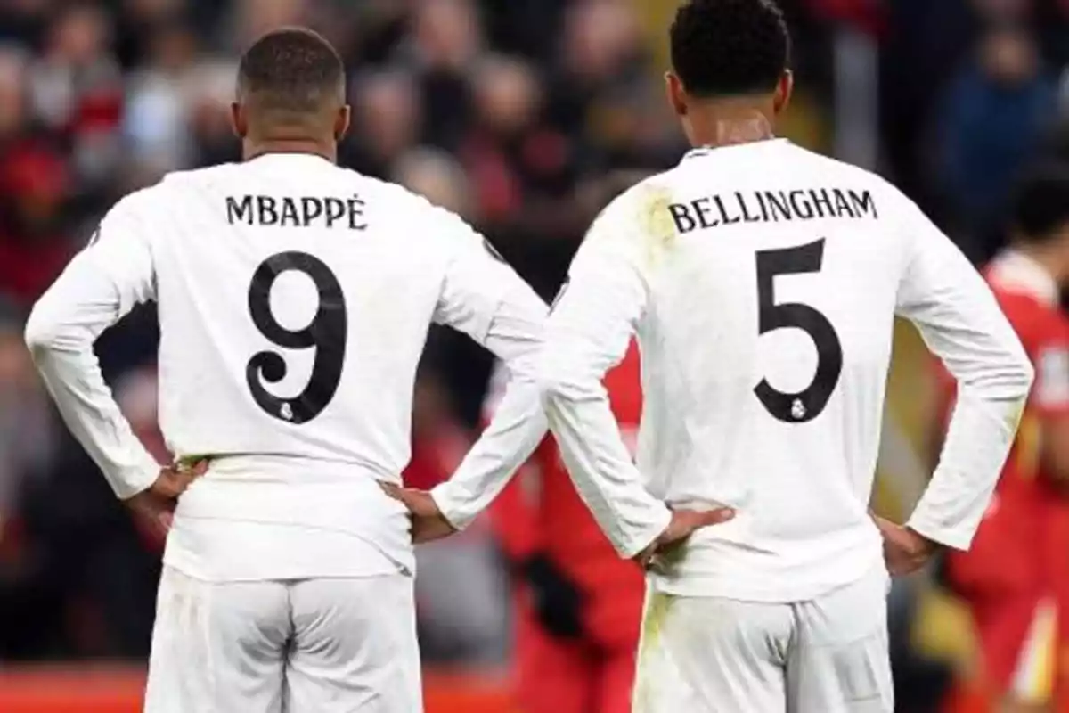 Dos jugadores de fútbol de espaldas con camisetas blancas y los números 9 y 5.