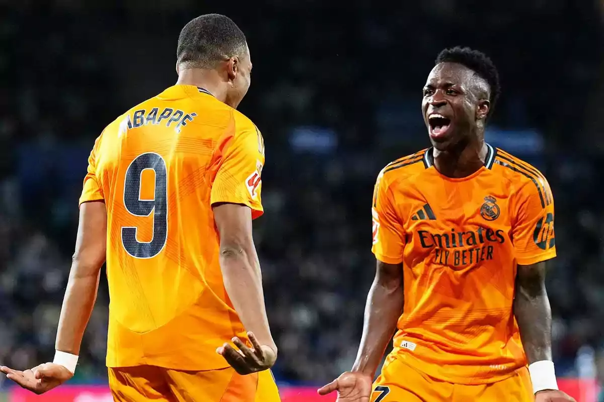 Two players in orange uniforms celebrate on the field.