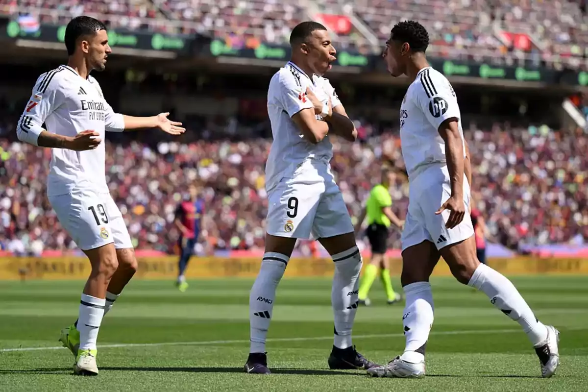 Real Madrid players celebrate on the field during a match with the stadium full of spectators.