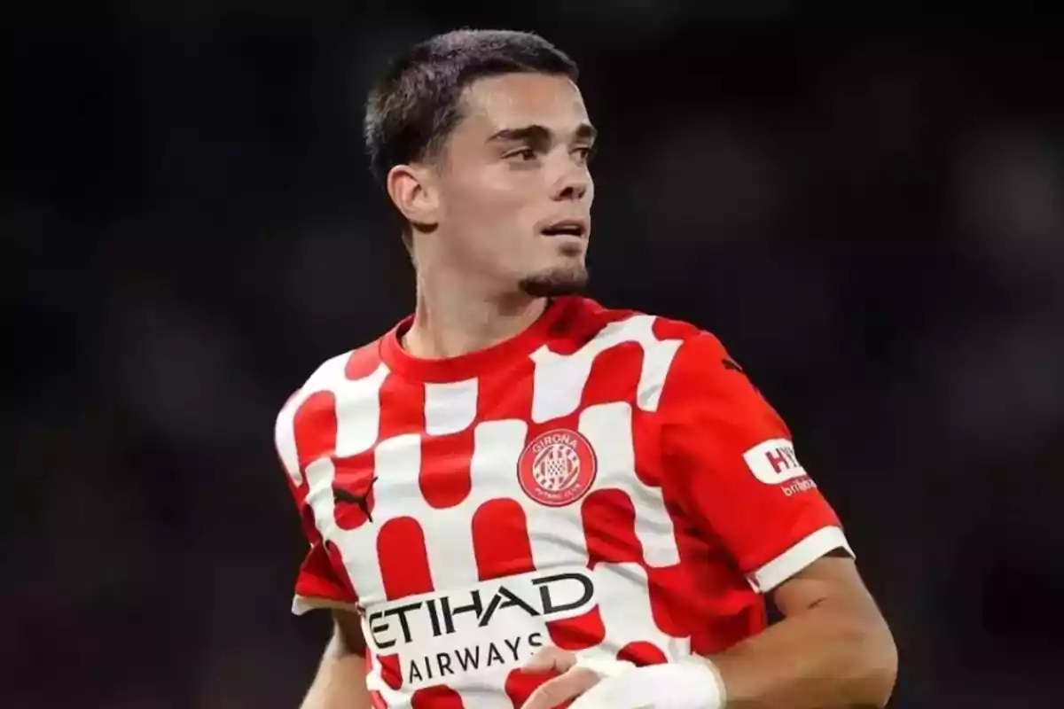 Football player in a red and white Girona FC jersey during a match. Football player in a red and white Girona FC jersey during a match.