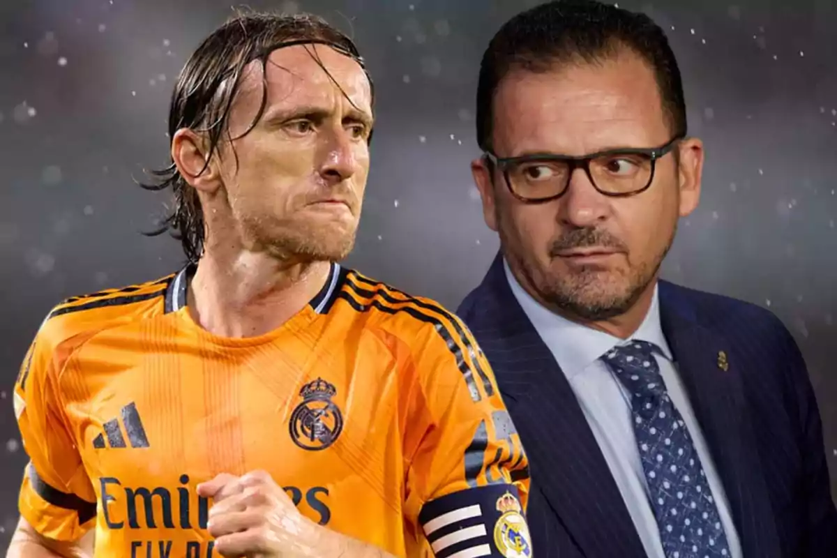 A player in an orange Real Madrid uniform next to a man in a suit and glasses, both looking in opposite directions.