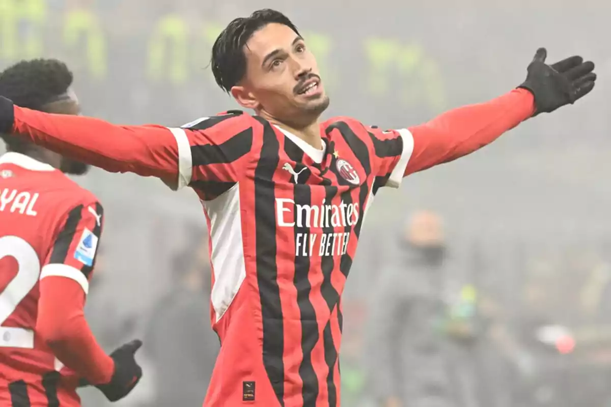Football player in AC Milan uniform celebrating with arms outstretched in a stadium. Football player in AC Milan uniform celebrating with arms outstretched in a stadium.
