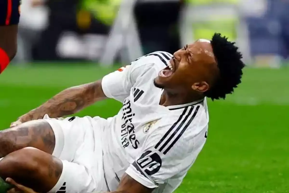 Jugador de fútbol en el suelo con expresión de dolor durante un partido. Jugador de fútbol en el suelo con expresión de dolor durante un partido.