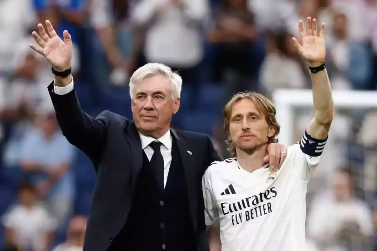 Dos hombres saludando al público en un estadio de fútbol. Dos hombres saludando al público en un estadio de fútbol.