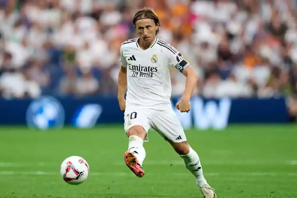 Jugador de fútbol con uniforme blanco en acción durante un partido. Jugador de fútbol con uniforme blanco en acción durante un partido.