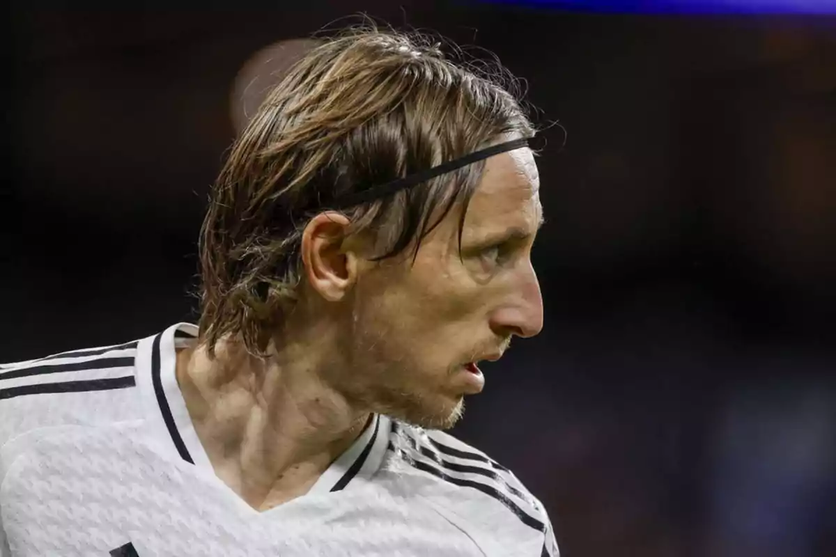 A soccer player in a black and white jersey looking to the right. A soccer player in a black and white jersey looking to the right.