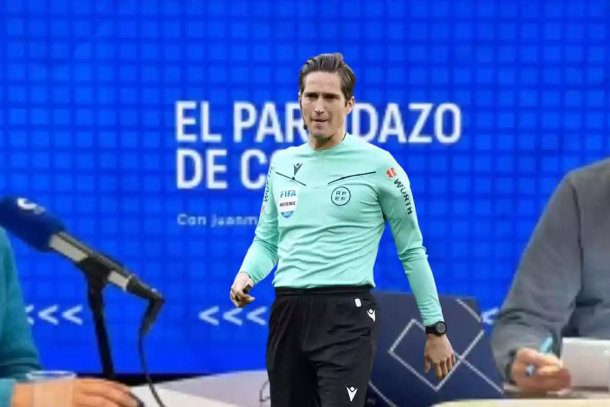 Un árbitro de fútbol con uniforme verde claro aparece frente a un fondo azul con el texto "El Partidazo de COPE" y un micrófono visible a la izquierda.