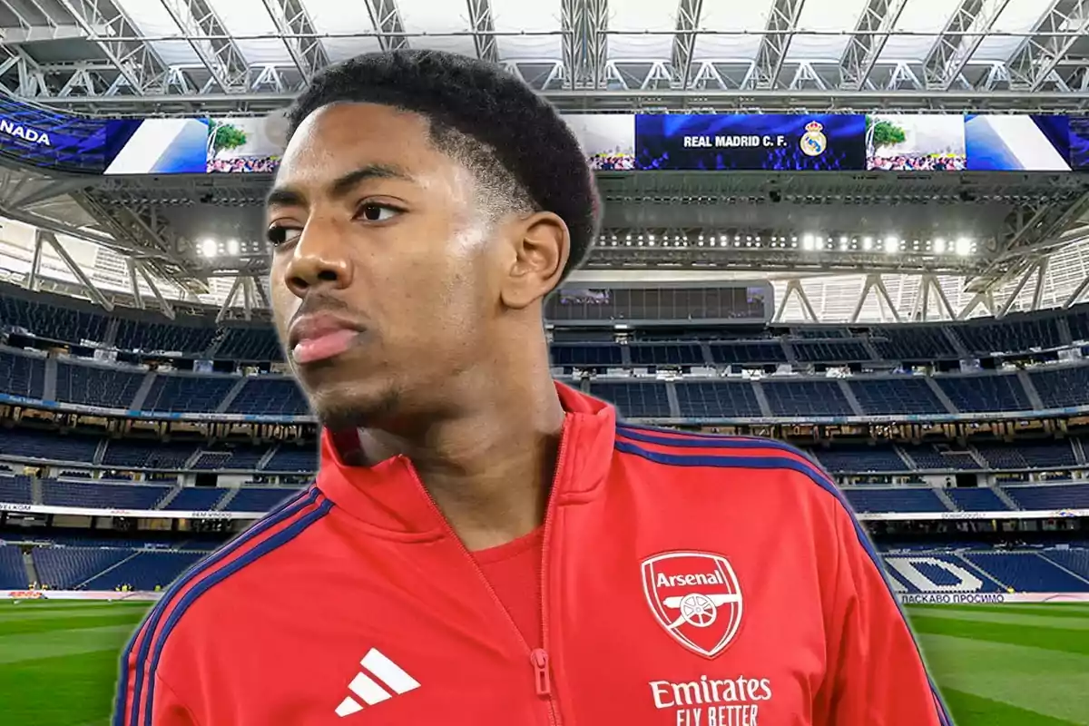 Player in a red Arsenal jacket in a modern, empty football stadium