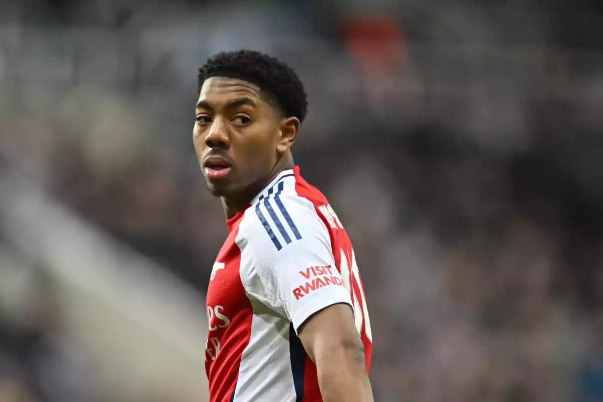Soccer player in a red and white Arsenal uniform looking back during a match Soccer player in a red and white Arsenal uniform looking back during a match