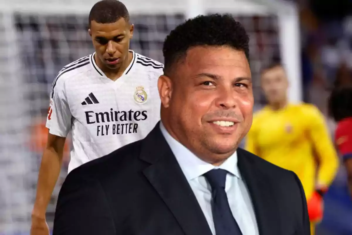 Two men on a soccer field, one in a suit and the other in a Real Madrid sports uniform.