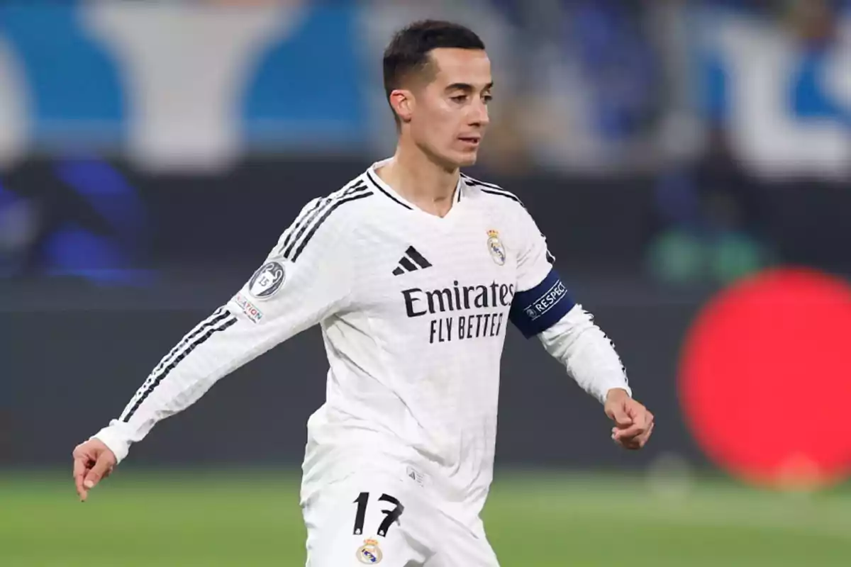 Football player in white Real Madrid uniform on the playing field.