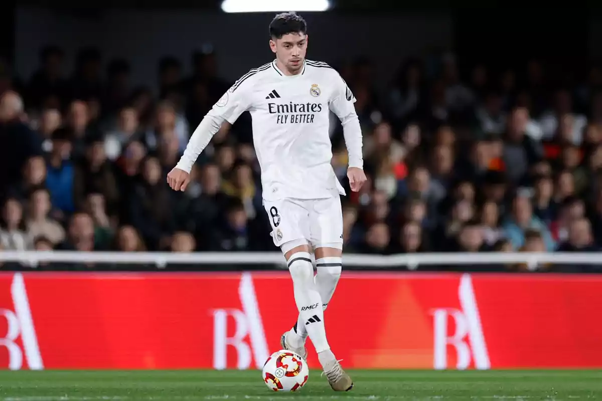 Real Madrid soccer player in action during a match, wearing the team's white uniform and controlling the ball on the field. Real Madrid soccer player in action during a match, wearing the team's white uniform and controlling the ball on the field.