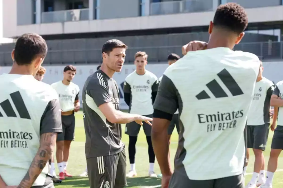 Soccer coach giving instructions to a group of players during an outdoor field practice