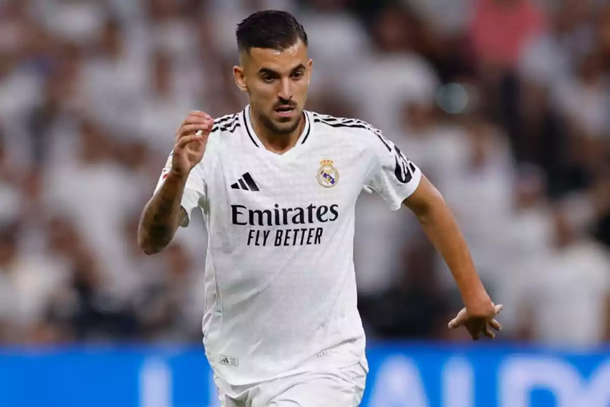 A soccer player in the white uniform of Real Madrid runs on the field during a match.