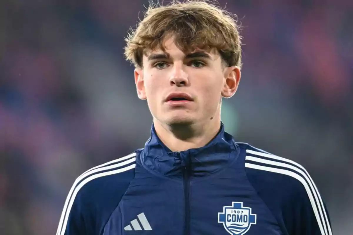 A young man in a blue sports jacket with the Como team logo. A young man in a blue sports jacket with the Como team logo.