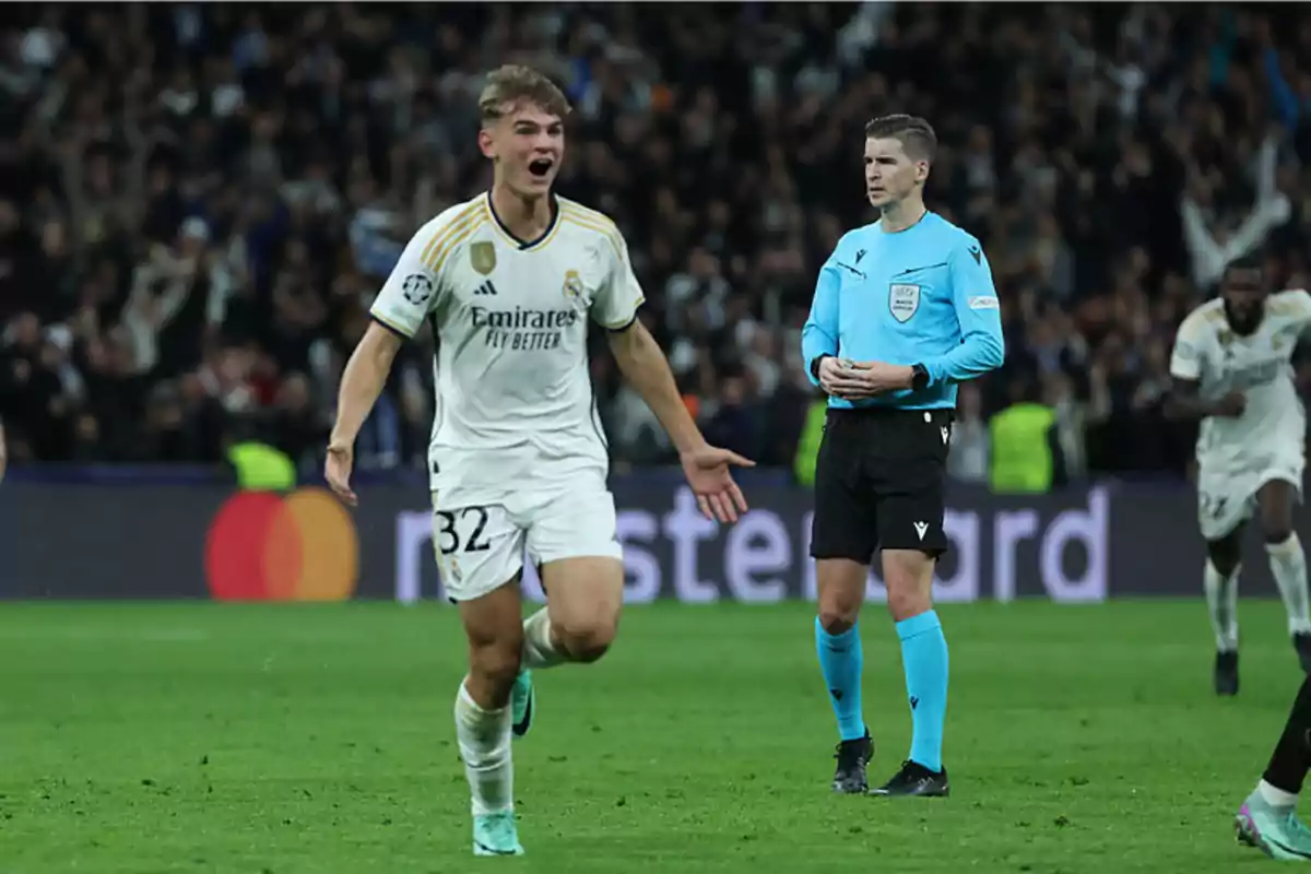 A soccer player celebrates on the field while a referee watches in the background. A soccer player celebrates on the field while a referee watches in the background.