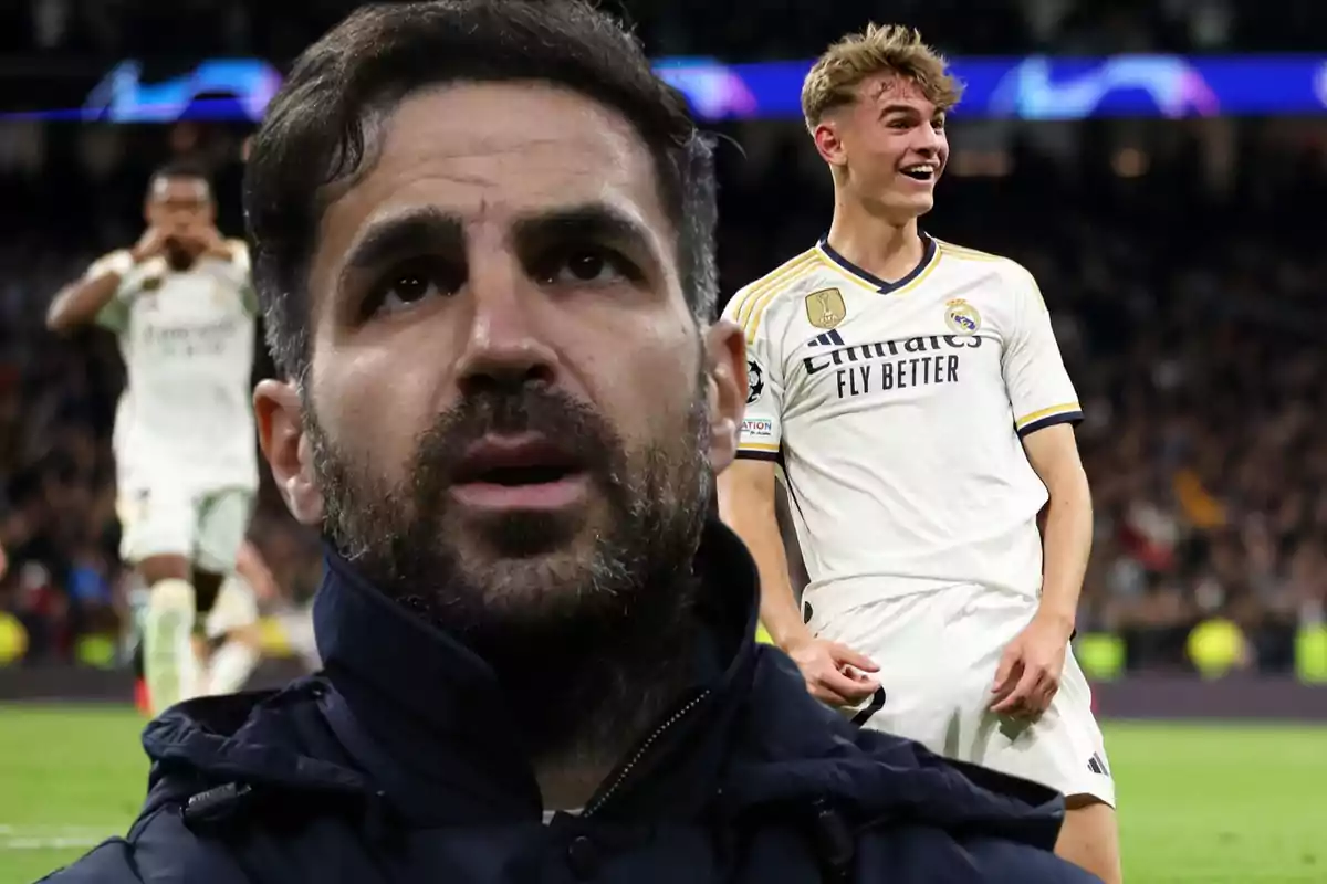 Un hombre con barba en primer plano y un jugador de fútbol del Real Madrid celebrando en el fondo durante un partido.