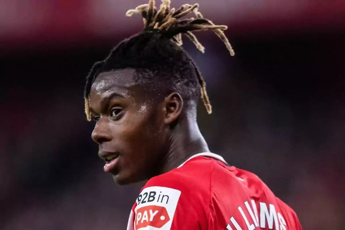 A soccer player in a red jersey and with blond dreadlocks hairstyle in a stadium. A soccer player in a red jersey and with blond dreadlocks hairstyle in a stadium.