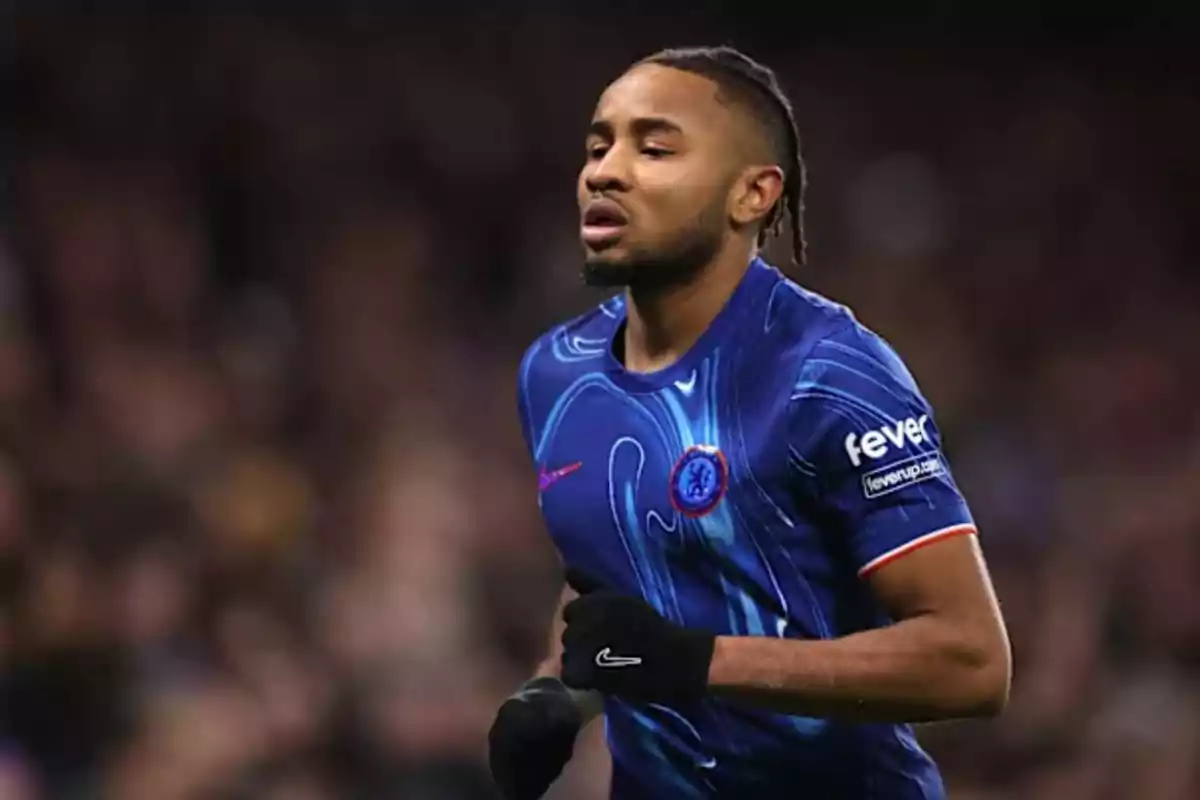 Un jugador de fútbol con uniforme azul corre en el campo durante un partido.