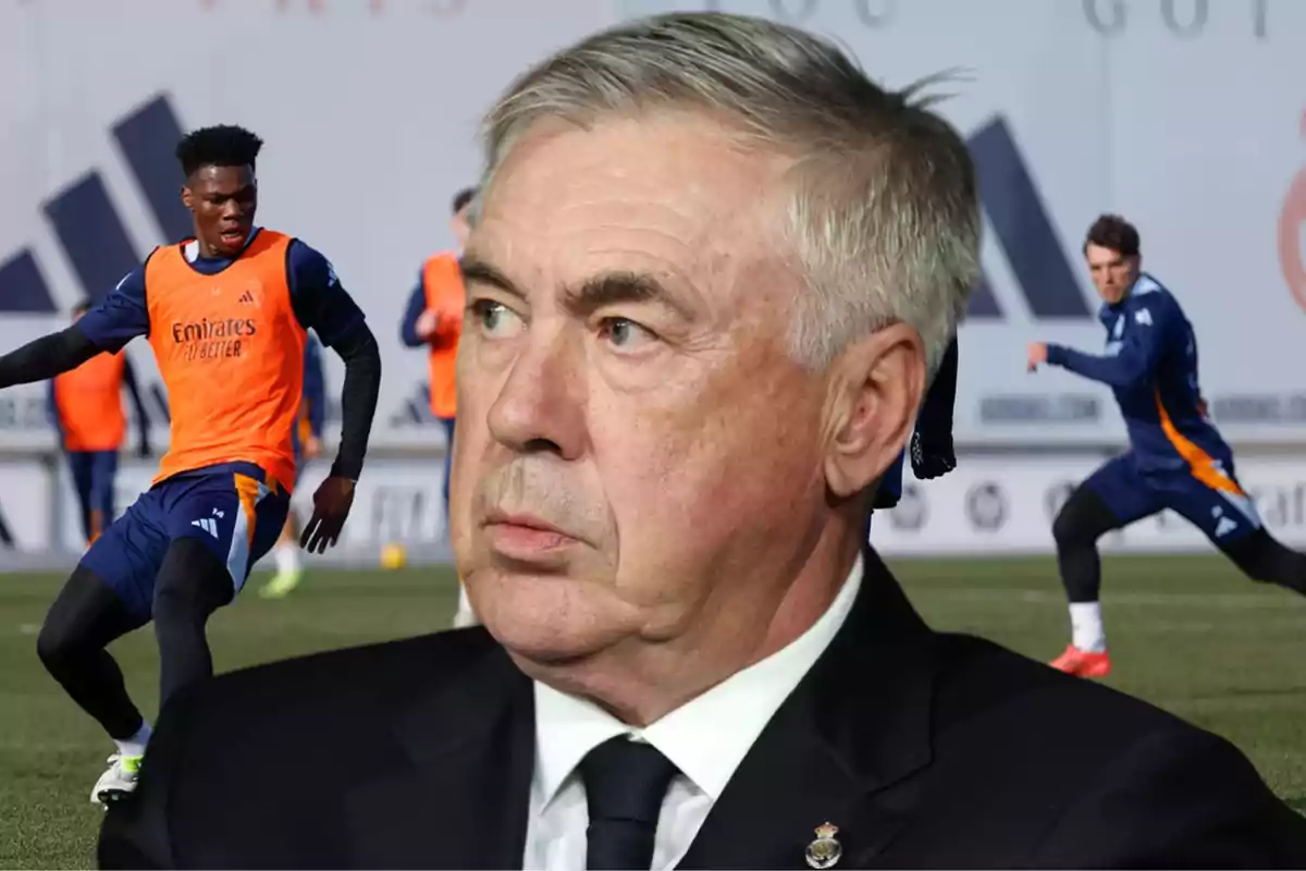 A soccer coach watches intently as his players train on the field.