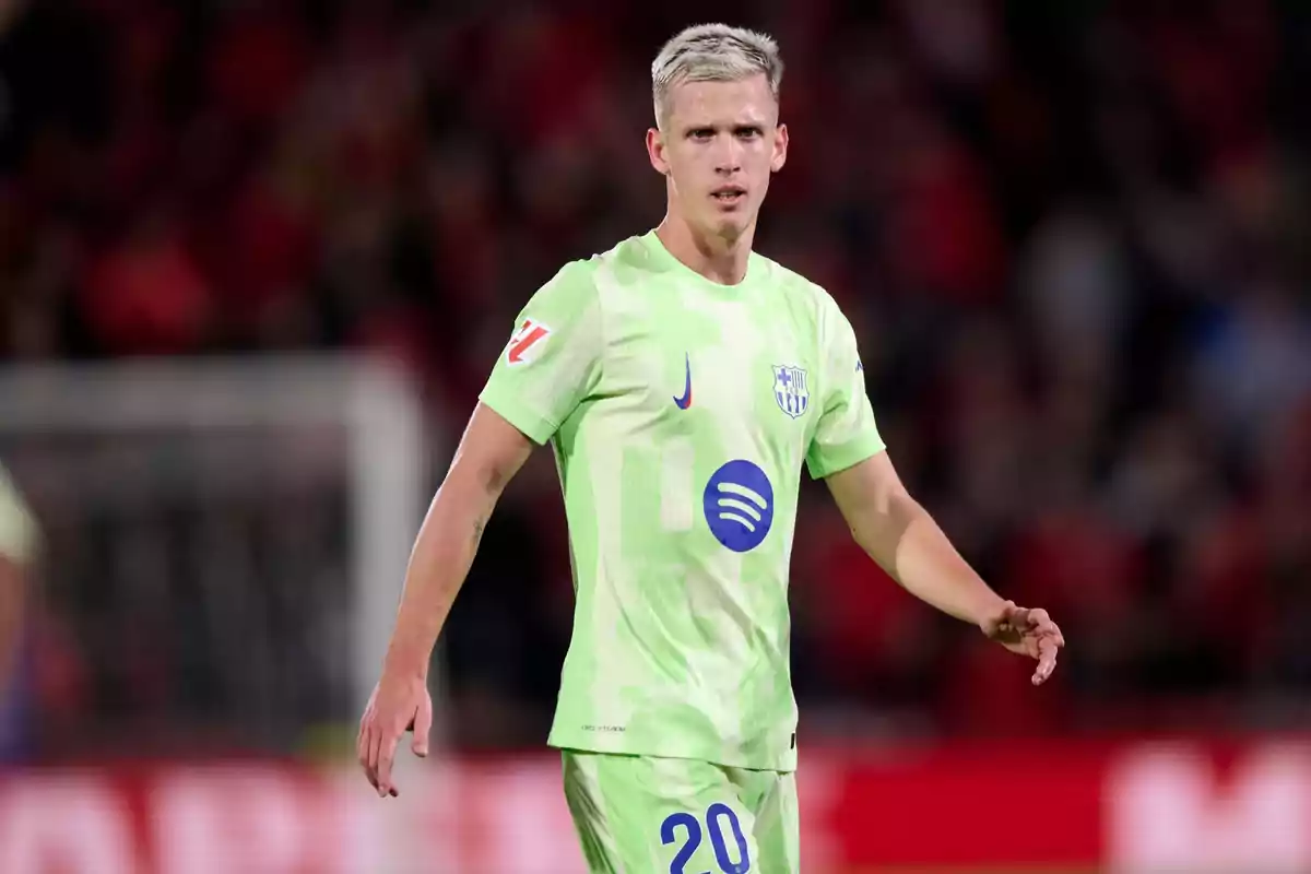 Football player on the field in light green uniform during a match. Football player on the field in light green uniform during a match.
